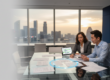 Diverse team in Singapore office reviews multilingual documents at glass table with skyline view.
